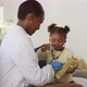 African american girl using stethoscope and smiling during medical home visit