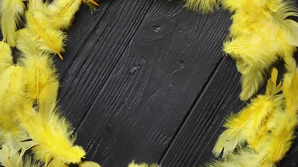 Colorful Decorative Easter Feather Wreath on Black Wooden Table Background alt