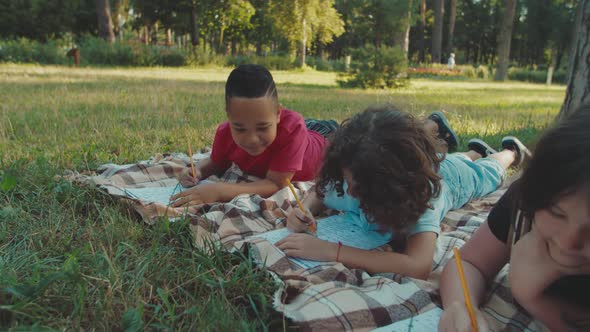 Closeup of Multiracial Diverse School Children Writing Exam Outdoors alt