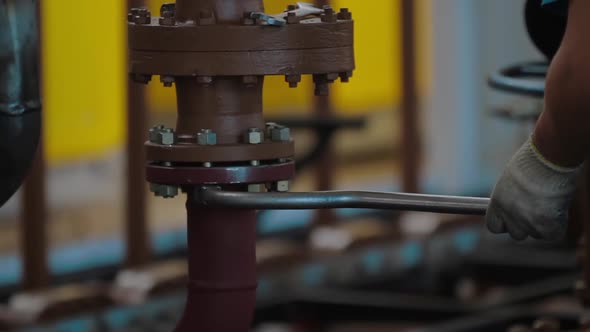 Worker Tightens the Bolt with a Wrench. Worker Assembles Oil and Gas Equipment in Industrial Plant alt