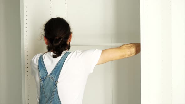Man is installing the hanger in the wardrobe