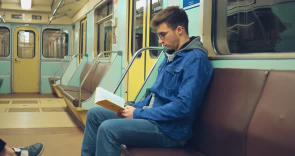 Brutal Guy in Jeans is Reading a Book in an Empty Carriage alt