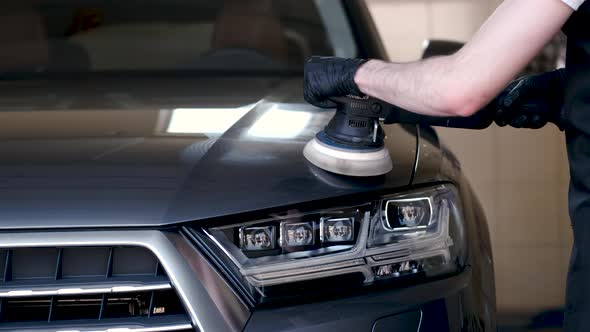 Man Polish a Car in a Garage alt
