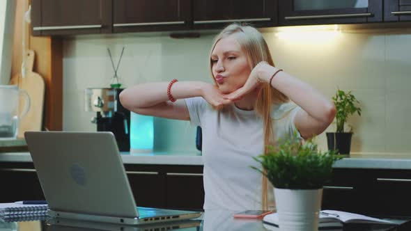 Cheerful Woman Singing and Gesturing While Looking on the Computer Screen alt