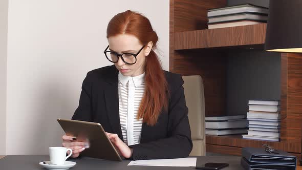 Stylish Redhead Girl Works with Papers at Home Office