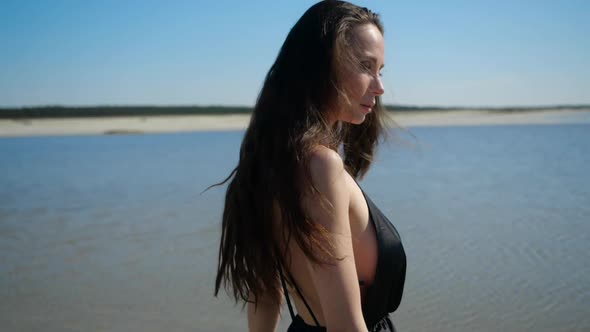 Sexy Slender Girl Whirls in Front of the Camera in a Seductive Dress on the Bank alt