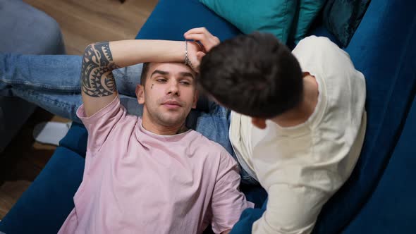 Top View Portrait of Happy Relaxed Gay Man Lying on Lap of Boyfriend Smiling Talking alt