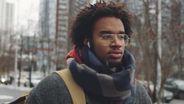 Young Afro-American Man Walking with Coffee on Winter Day alt