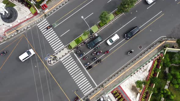 Aerial view of cars and motorbikes at traffic lights during the day