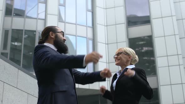 Man and Lady in Suits Making Winner Gesture and Smiling, Successful Business