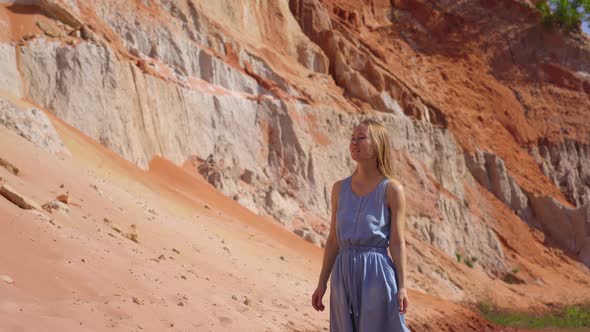 A Woman Walks Along a Red Canyon or Fairy Stream at the Border of Desert in the Mui Ne Village in alt