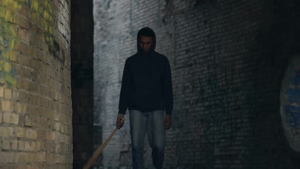 Black Teenager Walking Abandoned City Area With Baseball Bat, City Danger alt