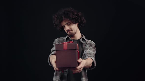 Portrait of a Shy Boy Smiling Holding a Box Containing a Gift alt