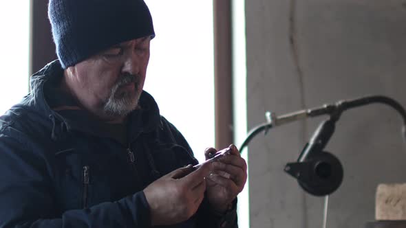 Blacksmith Forges and Tempering Metal Horseshoe in Jar with Water at Forge alt