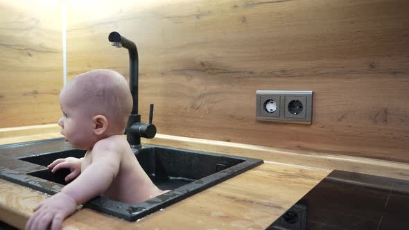 Baby in Kitchen Sink Bathing and Playing with Water