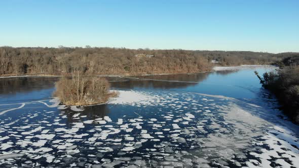 Aerial video over a beautiful half frozen lake in the heart of rural America alt