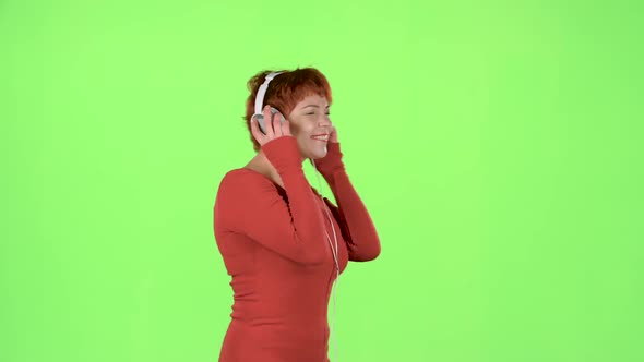 Red Haired Woman Listening To Music on Headphones. Green Screen alt