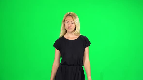 Pensive Girl Is Walking on a Green Screen at Studio alt