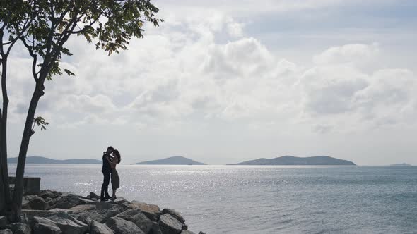 Couple Hugging on Rocks By the Water alt
