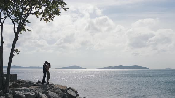 Couple Hugging on Rocks By the Water