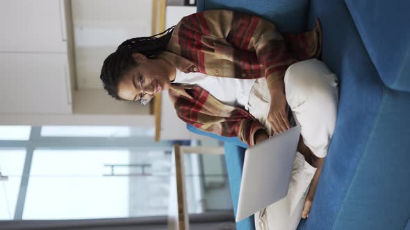 Woman with Dreadlocks is Working Using Laptop on Couch Communication Concept alt