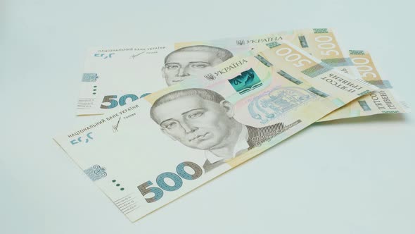 Recalculation of money. Hands count Ukrainian hryvnia bills on white background. Five hundred hrywna