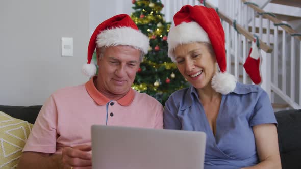Animation of happy caucasian senior couple having video call at christmas time alt