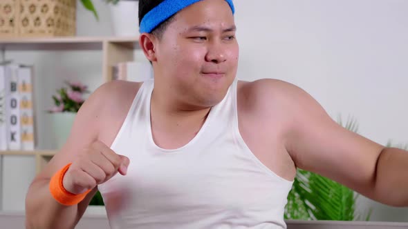 Fat Asian funny man doing warm-up aerobic exercise session training at home indoor alt