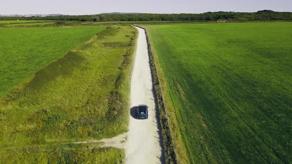 The car is moving on a sandy country road. Slow motion .