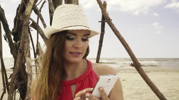 Woman Using Smartphone On Beach alt