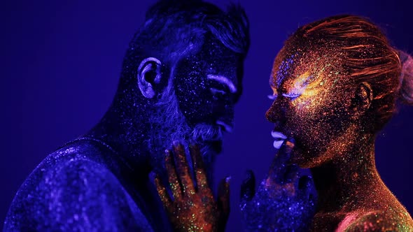 A Man and a Woman in the Ultraviolet Light Caress Each Other alt