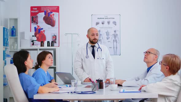 Young Specialist Doctor Explaining Diagnosis for Patients Treatment Issues Record alt