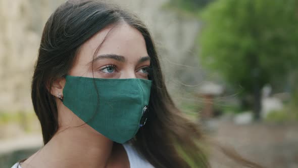 Young Woman In Green Protective Mask In Park
