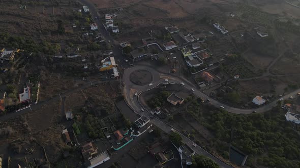 Roundabout in Portuguese village covered with volcanic ash on La Palma island. Aerial top-down circl alt