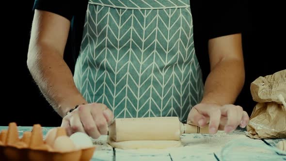 Baker Hands Preparing Fresh Dough with Rolling Pin on Kitchen Table. Man Forming the Dough on a alt