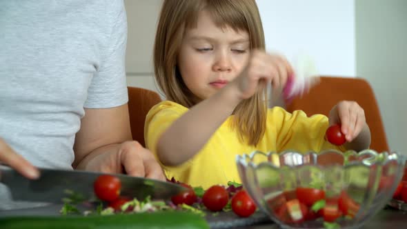 Daughter Helps Father to Prepare Salad of Vegetables on Kitchen