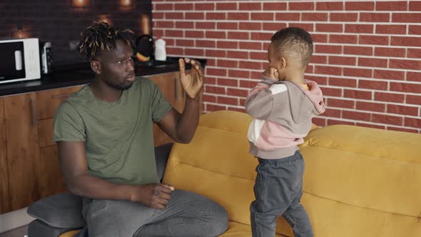 African Male and His Little Son Spend Time Together Fooling Around with Boxing Kicks alt
