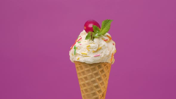 Сone of Vanilla Ice Cream with Sprinkles and Cherry 