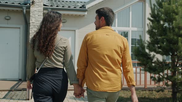 Joyful Husband and Wife Walking to New House Front Door Talking Smiling Outdoors alt