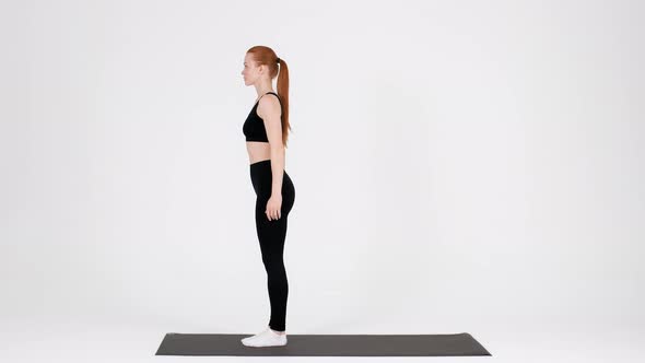 Sporty Young Woman Making Back Lunges Exercise in Studio alt