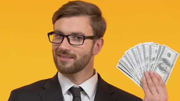 Smiling Man Holding Cash in Hand, Perks and Bonuses, Isolated Bright Background alt