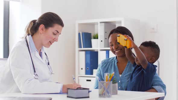 Happy Mother with Baby Son and Doctor at Clinic alt