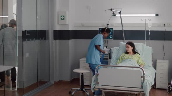 Afroamerican Nurse Checkup Sick Woman Analyzing Pulse Using Medical Oximeter alt