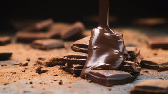 Chocolate pouring on chocolate bars on black slate background alt