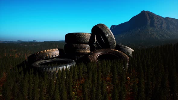 Concept of Environmental Pollution with Big Old Tires in Mountain Forest alt