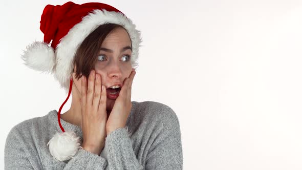 Young Beautiful Woman in Christmas Hat Looking Surprised or Shocked alt