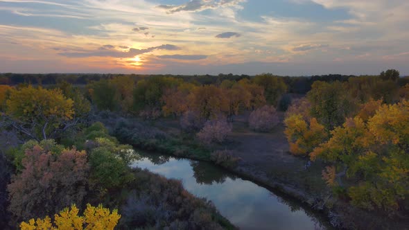 An autumn sunset reflects in mimicked colors a ok game the Platte River in Colorado. alt