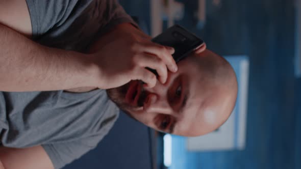 Vertical Video Close Up of Shocked Man Dropping Phone After Hearing Horible alt