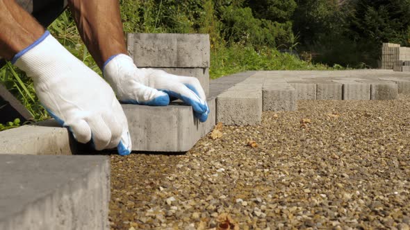 Builder Laying Pavement Rocks on the Street alt