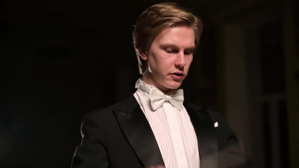 Close-up and slow motion of a young conductor who directs orchestra alt